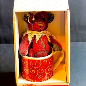 Antique teddy bear in a mug.